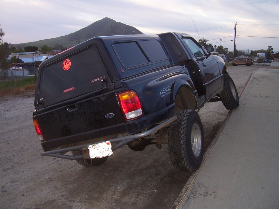 1998 Ford Ranger pickup truck with a cap, tilted on a ramp