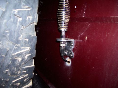 1989 Ford Bronco II - Close-up of an antenna mount attached to the side of a maroon vehicle, with a tire visible on the left.