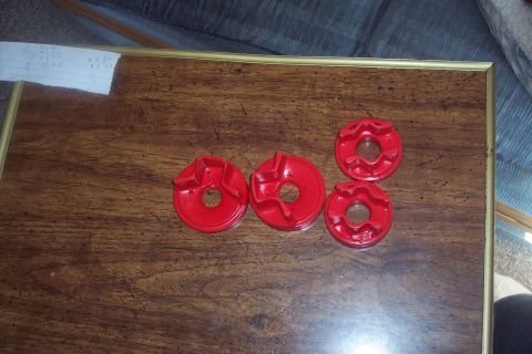 1995 Ford Probe - Four red motor mount inserts are laid out on a wooden surface next to a piece of paper with writing.