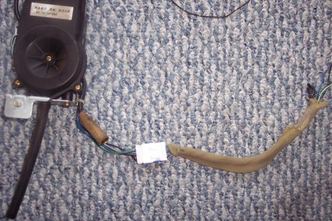 1995 Ford Probe - A power antenna assembly with visible wiring and a connector is shown against a carpeted background.