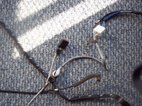 1995 Ford Probe - A close-up view of a vehicle's electrical wiring harness, showing various connectors and bundled cables.