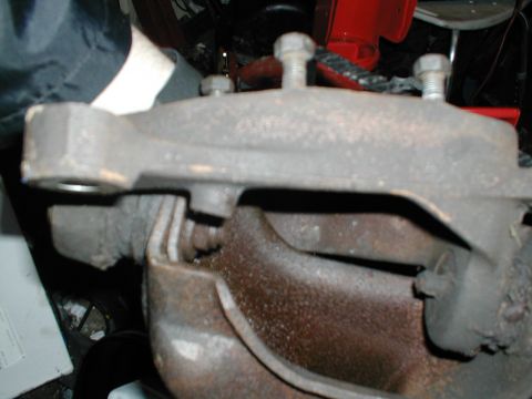 1979 Ford Bronco - This image shows a close-up view of a vehicle's brake caliper and rotor assembly, with visible bolts and rusty components.