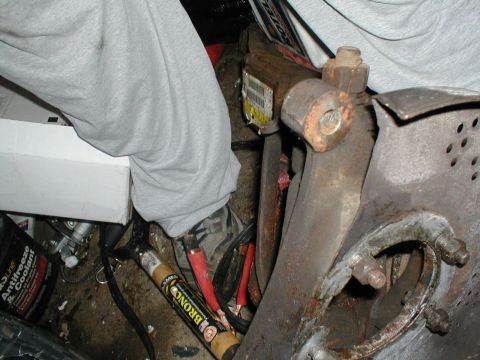 1979 Ford Bronco - Close-up of corroded vehicle components and electrical wiring, with a partial view of a person's legs.