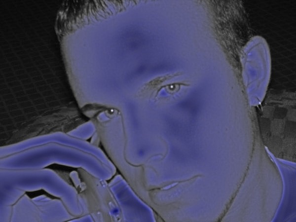 Close-up of a person's face with a hand near their mouth, wearing an earring
