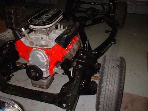 1964 Ford Galaxie - The engine and chassis are partially assembled, with a tire attached to the frame.