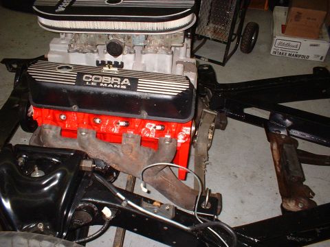1964 Ford Galaxie - Engine assembly with Cobra Le Mans valve covers and red block, partially mounted on a black chassis.