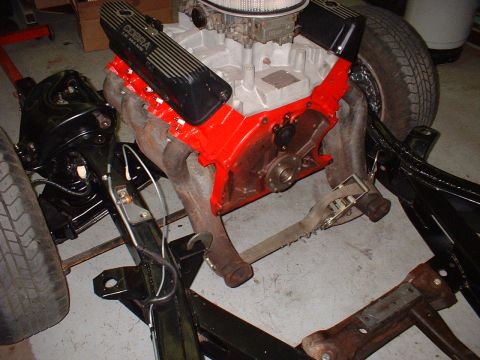 1964 Ford Galaxie - Engine assembly with black Cobra valve covers and red block, mounted on a chassis frame.