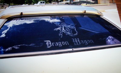 1972 Ford Ranchero - A white vehicle displays a "Dragon Wagon" decal and a dragon graphic on its rear window.