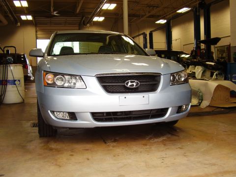 1997 Ford Taurus - A light blue Hyundai Sonata is parked head-on in a garage, showing its front grille and headlights.