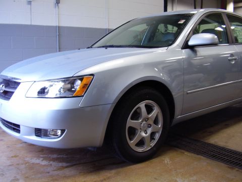 1997 Ford Taurus - Silver Hyundai Sonata sedan parked indoors, showing its front quarter panel and wheel.