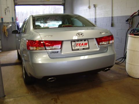 1997 Ford Taurus - The rear of a silver Hyundai Sonata is shown in a garage, dual exhaust pipes and a dealership license plate frame.