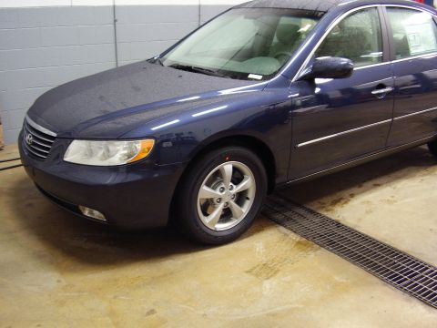 1997 Ford Taurus - Front quarter view of a blue sedan parked indoors.