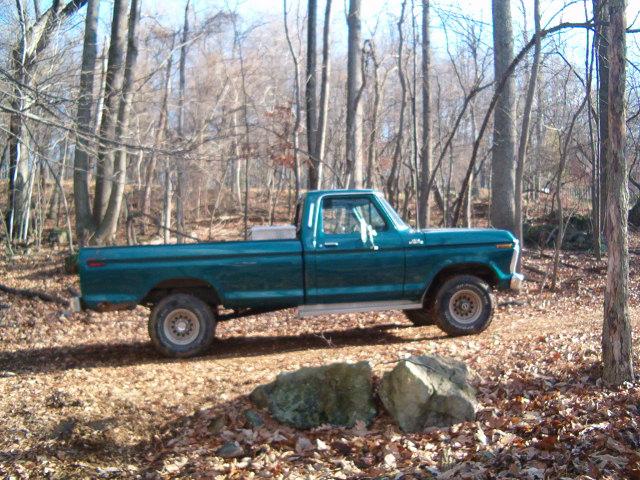 Teal green 1973-79 Ford F-series short bed pickup parked in autumn woods