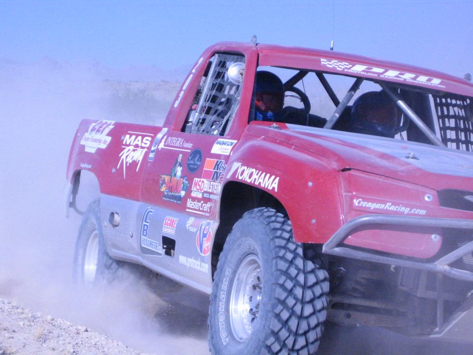Red race truck with Yokohama and Reagan Racing graphics in the desert