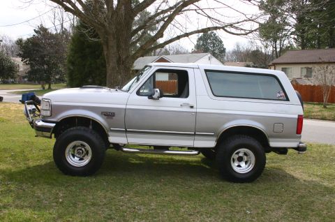 1994 Ford Bronco - This two-tone 1994 Ford Bronco features aftermarket wheels and tires, enhancing its appearance.
