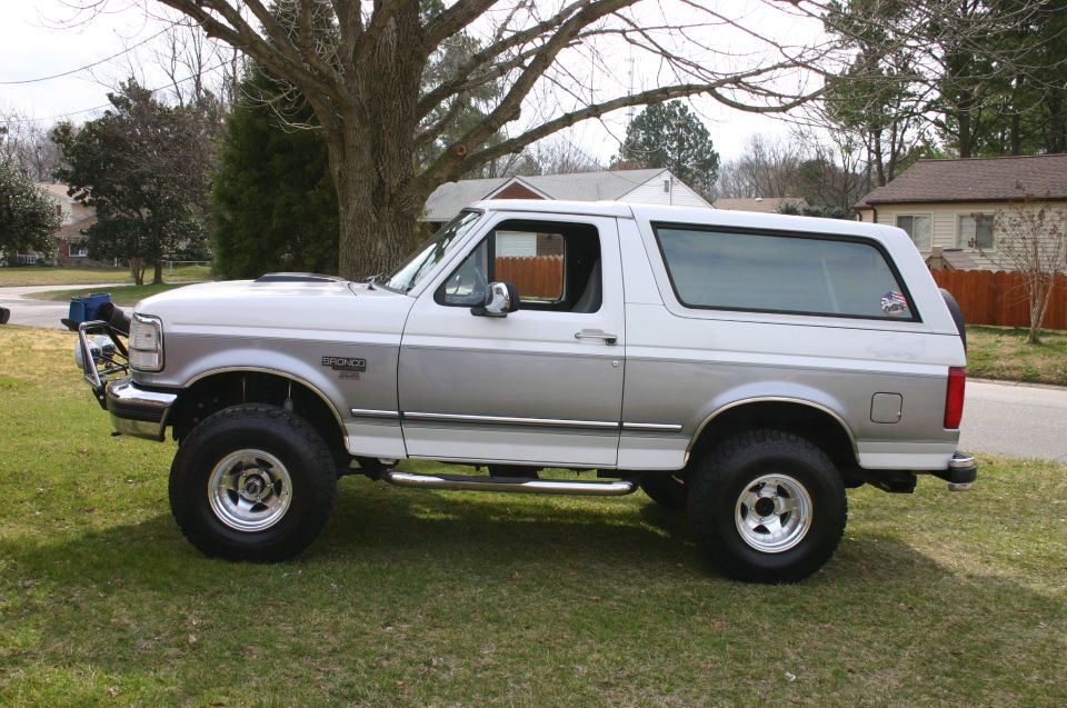 Lifted two-tone white and silver Ford Bronco XLT side view on a lawn