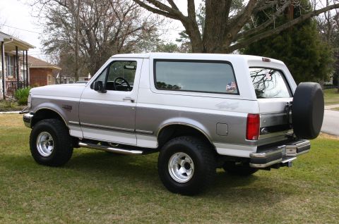 1994 Ford Bronco - Two-tone 1994 Ford Bronco with aftermarket wheels and tires, parked outdoors.