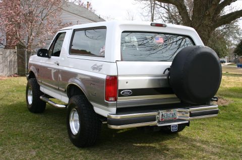 1994 Ford Bronco - This Ford Bronco has a spare tire mounted on the rear door, and a two-tone paint scheme with silver accents.