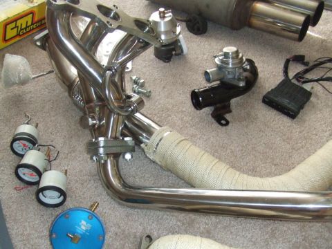 1995 Ford Probe - Collection of aftermarket automotive exhaust components and gauges, including a turbo and wastegate.
