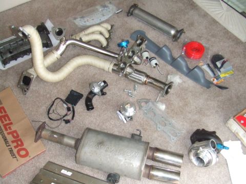 1995 Ford Probe - Various automotive performance parts are laid out, suggesting an upgrade or repair project.