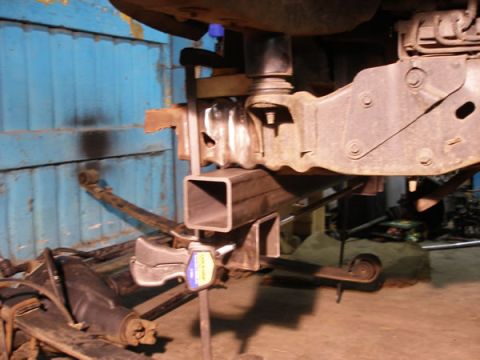 1994 Ford Bronco - A vehicle's suspension is being modified with new parts and a clamp holding a metal tube.