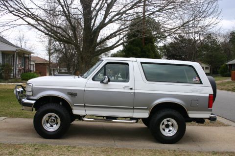 1994 Ford Bronco - This two-tone 1994 Ford Bronco is shown from the side, aftermarket wheels and a spare tire on the rear.