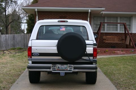 1994 Ford Bronco - Rear view of a white Ford Bronco with a spare tire mounted on the back.