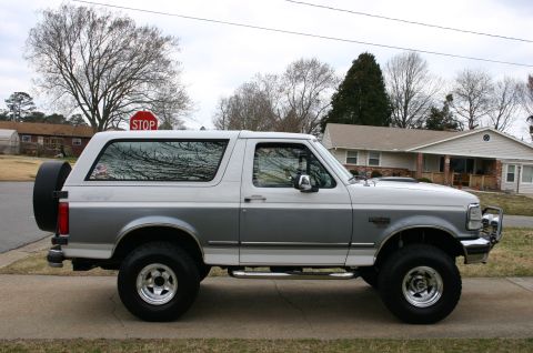 1994 Ford Bronco - Side view of a two-tone 1994 Ford Bronco parked on a suburban street.