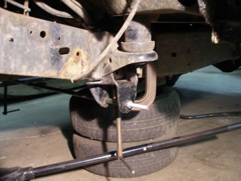 1994 Ford Bronco - A C-clamp is used to hold suspension components in place on a vehicle's frame.