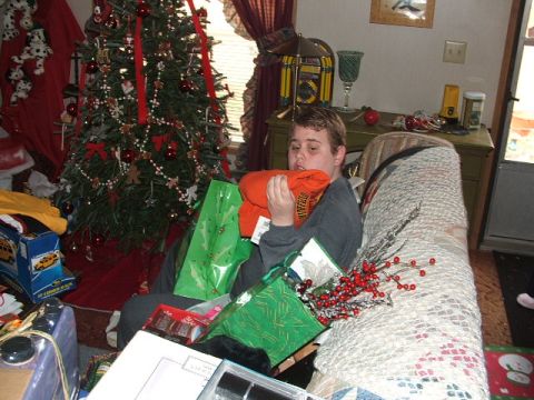 1966 Ford Ranchero - A person sits surrounded by Christmas gifts and decorations, opening an orange shirt.