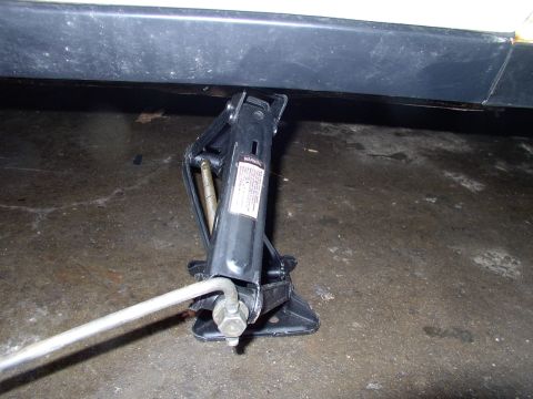 1990 Lincoln Town Car - Car jack is shown under the side of a vehicle, likely for tire change or repair.