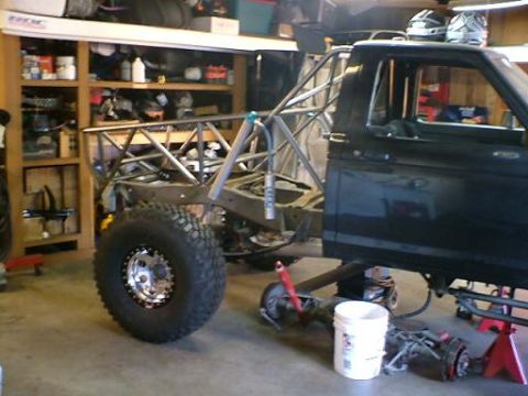 1977 Ford F-150 - Custom truck build in progress, showing the cab and chassis with a roll cage and large tire.