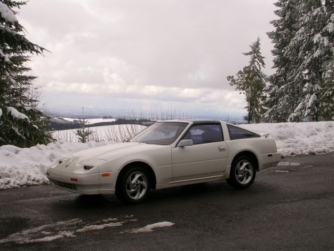 1989 Nissan 300ZX - A white Nissan 300ZX coupe is parked on a road covered in patches of snow, with snow-covered trees in the background.