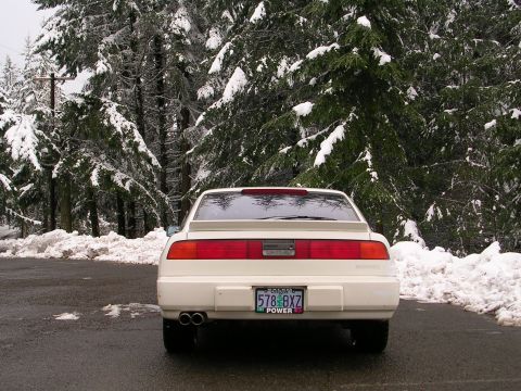1989 Nissan 300ZX - A white 1989 Nissan 300ZX is parked on a road with snow-covered trees in the background.