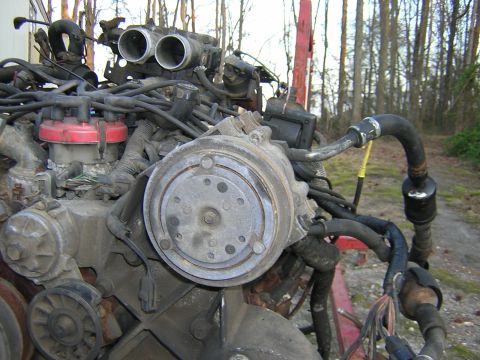 1979 Ford Bronco - Close-up view of an engine assembly, showing the air conditioning compressor and throttle body.
