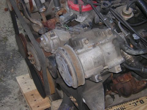 1979 Ford Bronco - Close-up view of engine components including pulleys, belts, and an AC compressor.