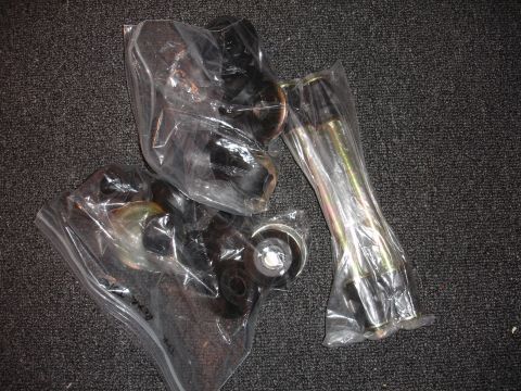1993 Ford Taurus - Automotive suspension parts are packaged in plastic bags on a dark carpeted surface.