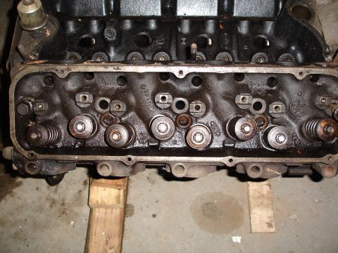 1979 Ford F-150 - Close-up of an engine cylinder head, showing valves, springs, and casting marks including the Ford logo.
