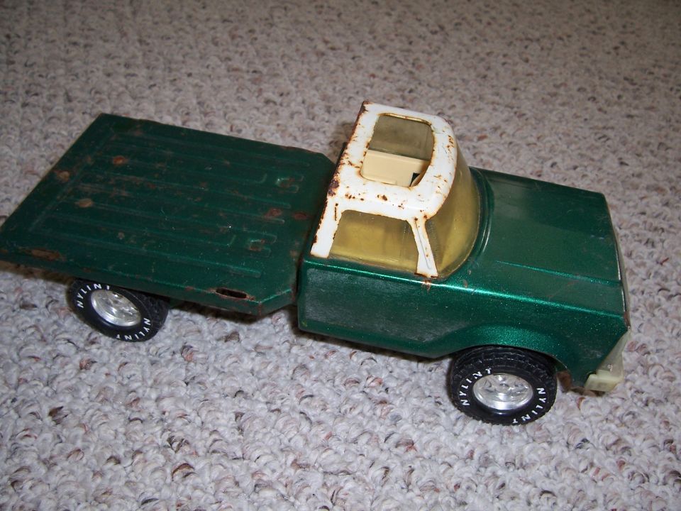 Green toy truck with a flatbed and white cab roof