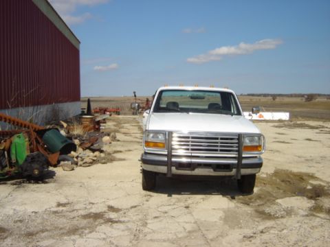 1992 Ford Bronco - A white 1992 Ford Bronco is parked in front of a red barn on a sunny day.