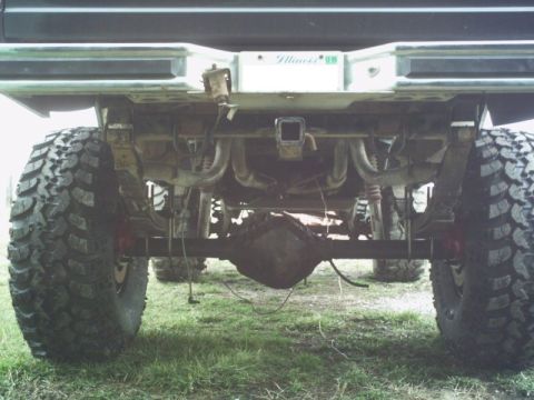 1986 Ford Bronco - The underside of a heavily modified truck, focusing on its off-road suspension and large tires.