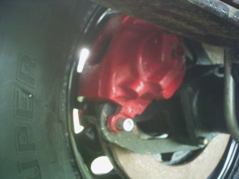 1986 Ford Bronco - Close-up of a vehicle's tire and red brake caliper.