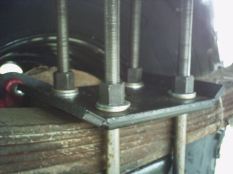 1986 Ford Bronco - Leaf spring pack with a U-bolt assembly attached to a metal plate.