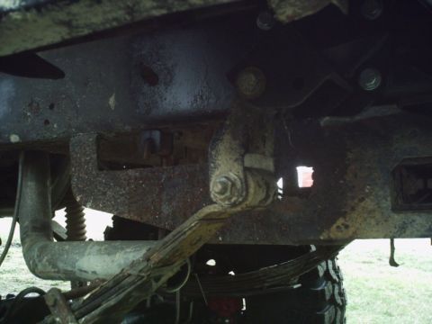 1986 Ford Bronco - Close-up view of a vehicle's rusty undercarriage, focusing on suspension components.