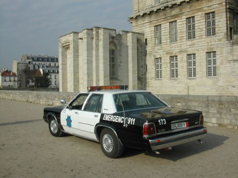1991 Ford Crown Victoria - A 1991 Ford Crown Victoria police car is parked in front of a large stone building.