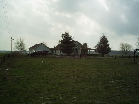 1986 Ford Bronco - A truck is parked in front of a house with a large grassy field in the foreground.
