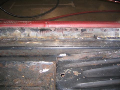 1969 Ford Mustang - Close-up view of a heavily welded and rusted metal frame, likely from a vehicle undergoing repair.