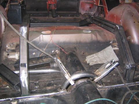 1969 Ford Mustang - Welding equipment and a custom metal frame are visible inside a car's interior during modification.