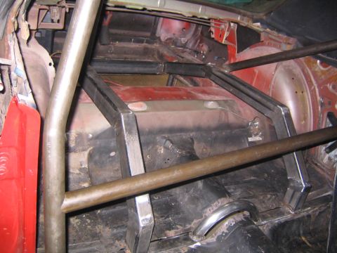 1969 Ford Mustang - Custom roll cage installed in the interior of a red vehicle, likely for racing or performance modification.