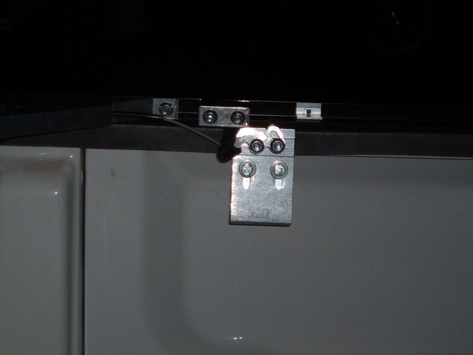 Tonneau cover hinge on white truck bed